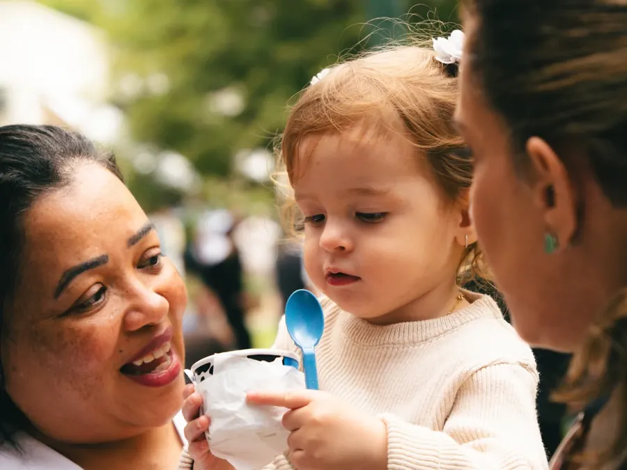 Criança tomando sorvete Berry's no colo da família