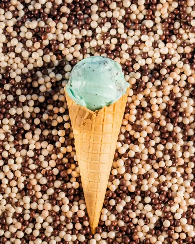 Casquinha de sorvete azul sobre confeitos de chocolate