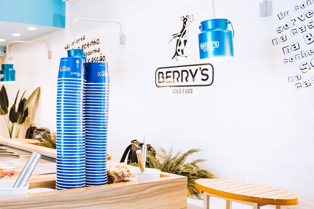 Loja Berry's com copos azuis e balcão de madeira
